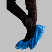 Persona usando cubrezapatos con antiderrapante desechable azul